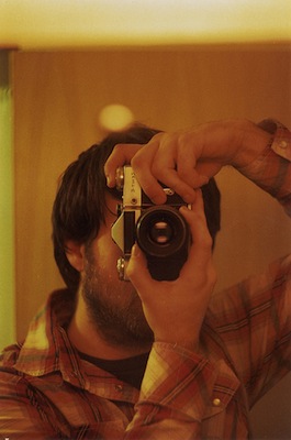 A man takes a photo with a Zenit E SLR camera